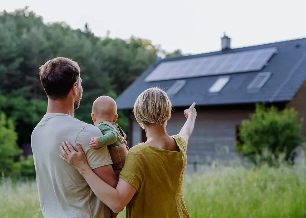 Une famille regardant les panneaux solaires sur le toit de leur maison